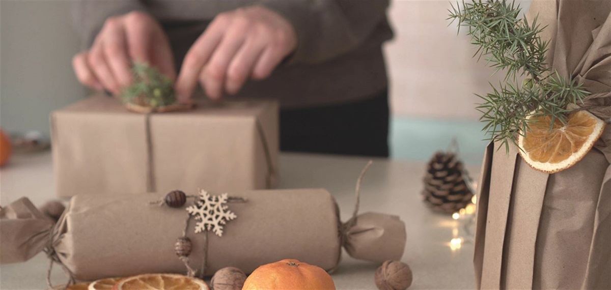 person wrapping a gift in paper bag